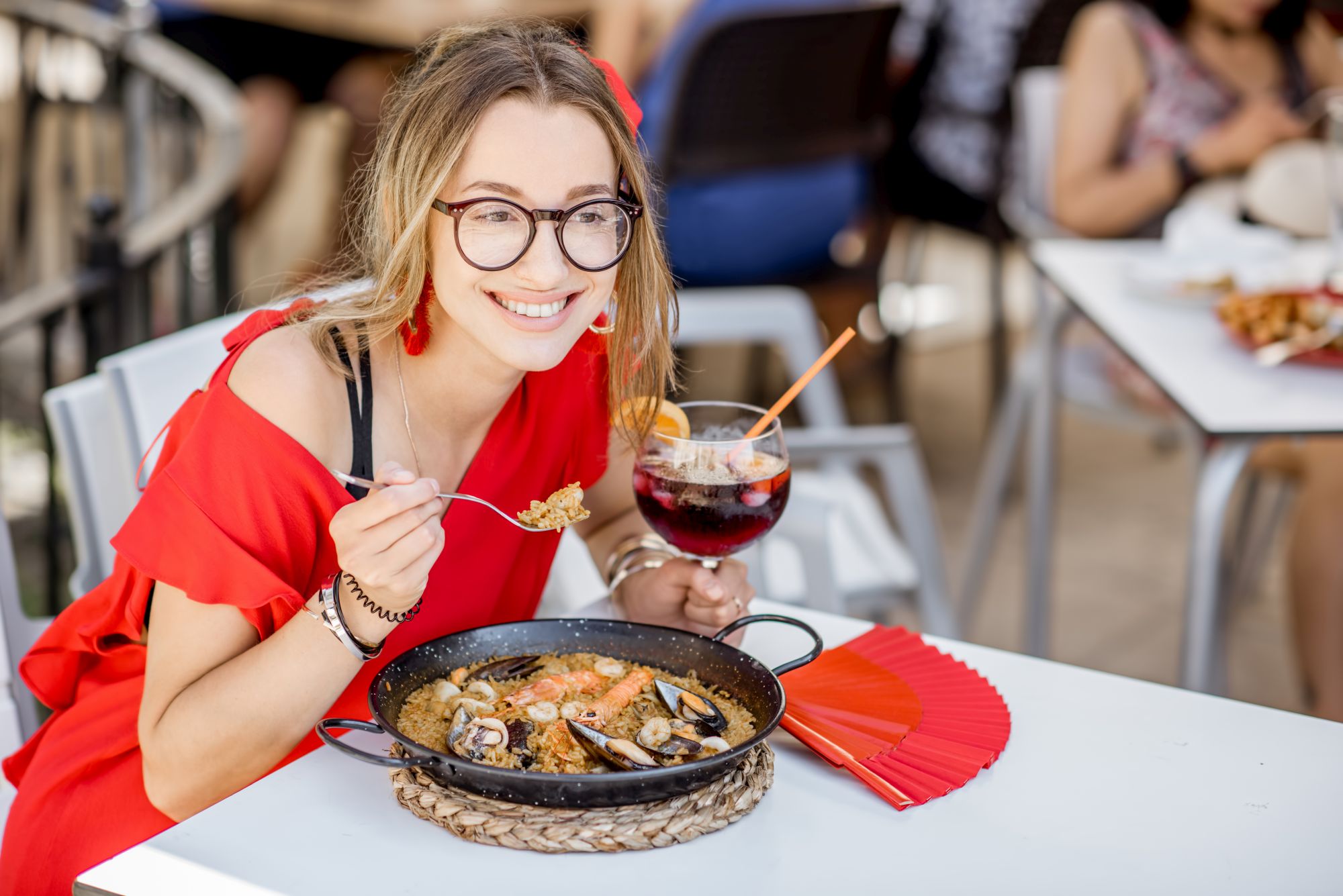 Woman eating Paella dish at the restaurant