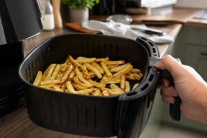 Cartofi prăjiți gătiți într-un strat aerisit la air fryer