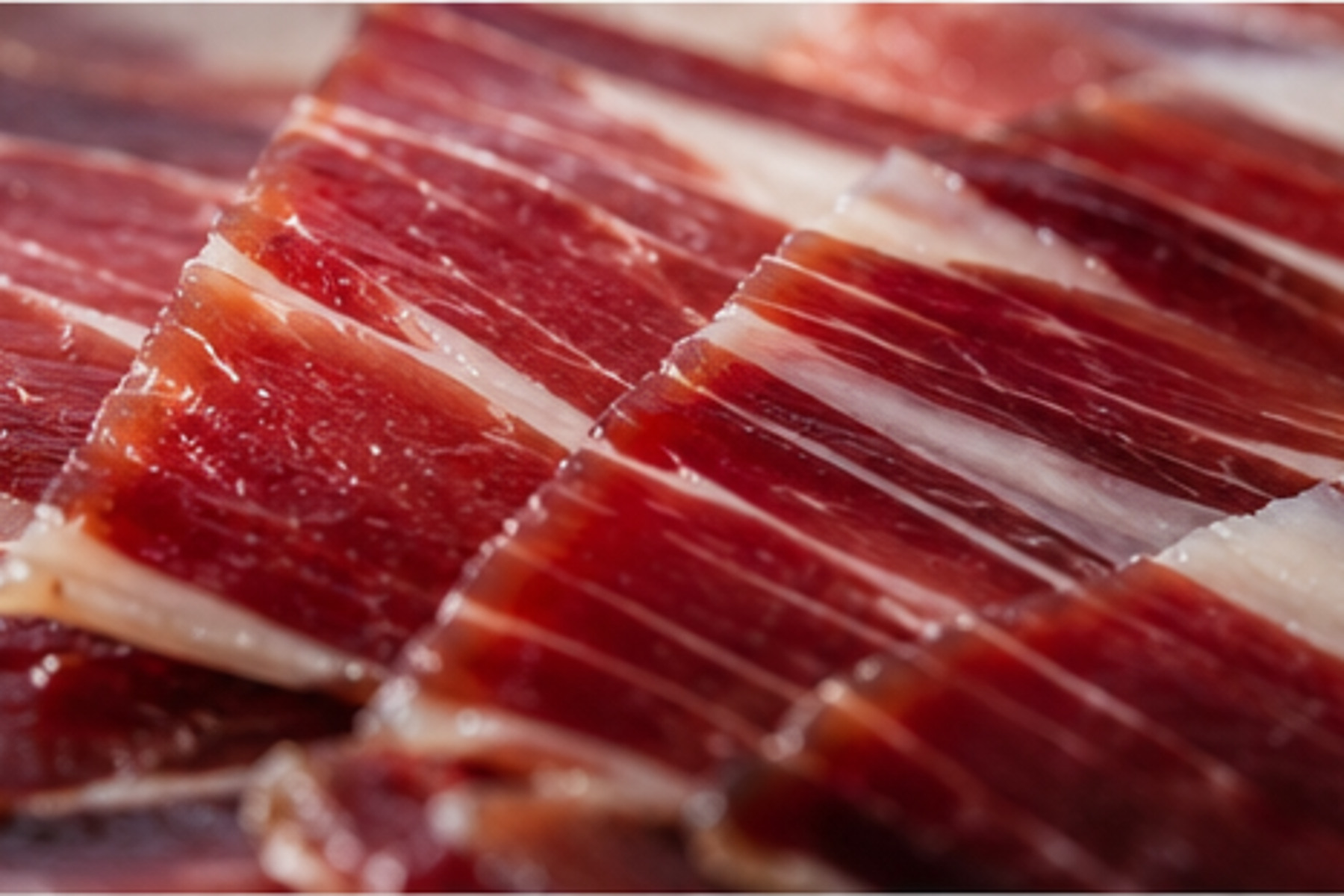 Detaliu cu felii de jamón ibérico roșu-rubiniu și grăsime intramusculară